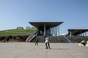 Young woman skates outside the Inner Mongolia Museum, another example of massive infrastructure designed to promote unity in regional areas.